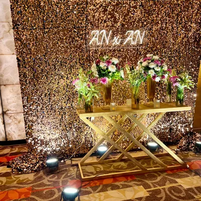 A custom neon sign featuring your event hashtag or company initials adds a modern, personal touch. Placed against a glamorous sequin backdrop, it creates the perfect, shareable photo moment for your guests.