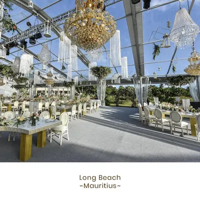 A spectacular wedding reception we catered at Long Beach, Mauritius. The transparent marquee, adorned with magnificent chandeliers, allowed guests to dine under the sky, blending opulent decor with the beauty of a tropical paradise.