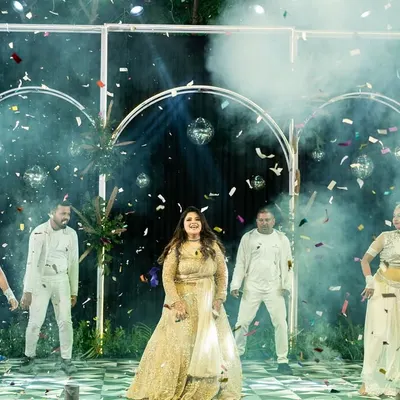 A bride's solo performance is all about joy and celebration. Here, Mahek is surrounded by backup dancers and confetti, creating a grand, cinematic moment during her sangeet.