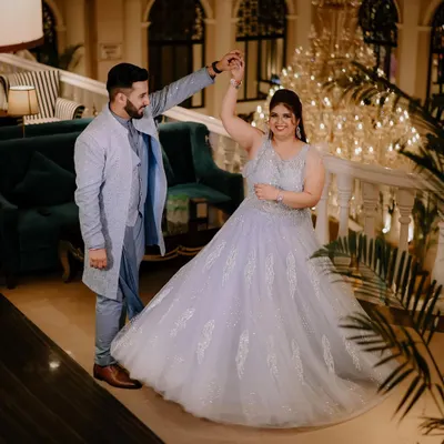 A beautiful moment from a ring ceremony, where the couple shares a dance. The grand chandelier and elegant setting add to the fairytale feel of this engagement party.