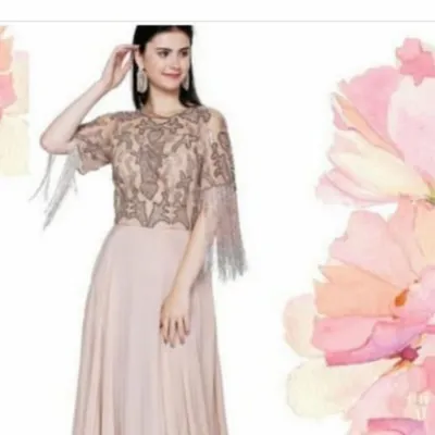 This beige gown features a stunningly detailed cape-style bodice with intricate beadwork and sparkling tassels on the sleeves. The flowing georgette skirt creates a graceful silhouette, perfect for any formal event.