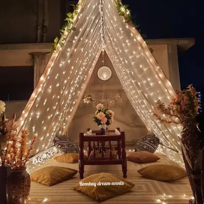 A romantic proposal and dinner date setup inside a beautifully lit tent on a rooftop. The fairy lights and cozy seating create a private, magical world for just the two of you.