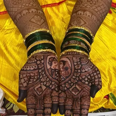 A close-up of a custom couple portrait, beautifully framed on the palm. The dark, rich stain you see is the result of my 100% natural henna paste, ensuring a safe and stunning look for your wedding.