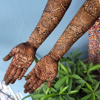 A perfect example of personalization. This bridal design features a beautiful heart in the center of the palm with the phrase 'Raja weds Rani' written inside, making it so special for the couple.