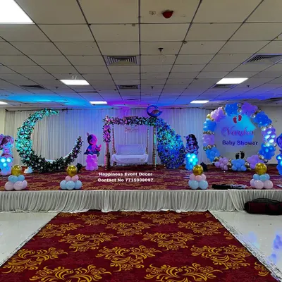 This is a complete baby shower stage I designed in a large hall. It features a traditional floral swing or 'jhula' for the parents-to-be, a large decorative crescent moon, and custom balloon arrangements, all brought together with professional stage lighting to create a magical atmosphere.