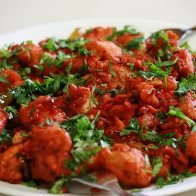 Spice up your event with our Gobi 65. These cauliflower florets are marinated in a spicy red masala, fried to perfection, and garnished with fresh coriander, making for a zesty and popular vegetarian starter.