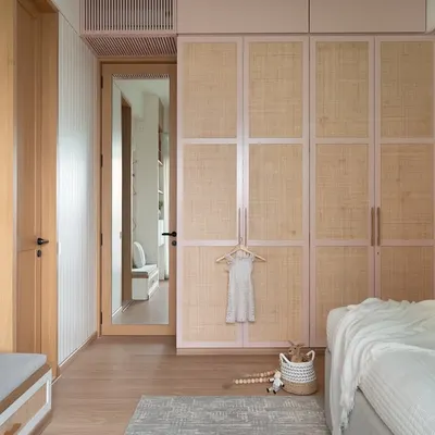 For a delightful 3-year-old client with a passion for pink, her dream bedroom came to life. The blush pink wardrobes with a rattan blend and a pastel rainbow mural make this a magical, personal haven.