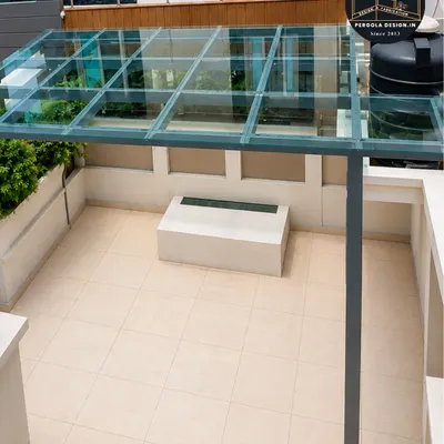 This high-angle shot shows the clean, minimalist aesthetic of our finished glass roof pergola. The structure provides complete rain protection for the terrace below without sacrificing the open, airy feeling of the space.