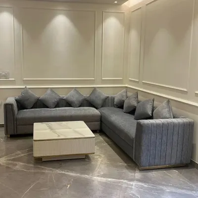 A custom L-shaped sectional sofa we designed for a contemporary living room. This piece features clean lines, plush grey upholstery, and a fluted design on the armrest, providing ample seating without compromising on style.