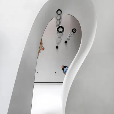 The sculptural staircase in the Worli Duplex is the defining element of the home. Its sweeping form creates a dynamic visual anchor that breaks from the apartment's otherwise orthogonal geometry.