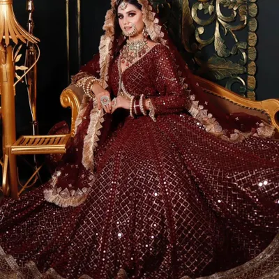 Make a grand entrance with this fully sequenced maroon bridal lehenga. The heavy jewellery set, featuring a choker and matching earrings, completes this royal look, perfect for a winter wedding reception.
