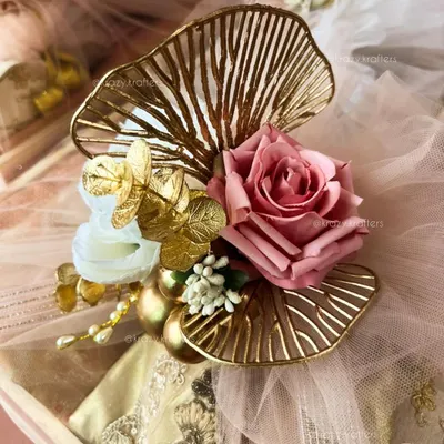 A close-up of the intricate details on my trousseau packaging. I use elements like these golden ginkgo leaf accents and artificial roses to create a rich, luxurious look.