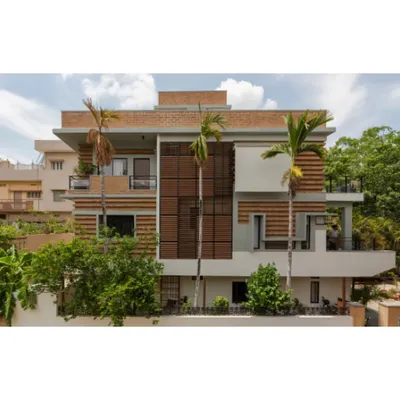 The facade of the Ananda residence in Hyderabad, where we renovated an existing structure to minimize waste. The new walls are built with compressed stabilised earth blocks (CSEB) in alternating courses, a technique that creates a self-shading, thermally efficient surface.