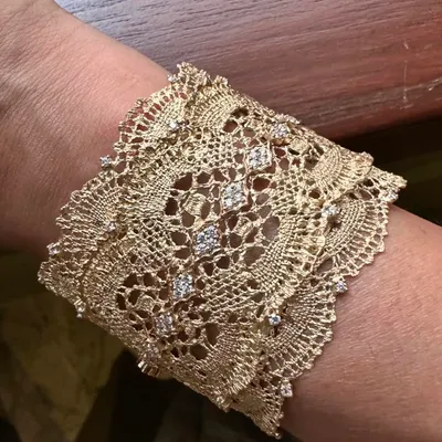 This is the essence of my lace-work: a wide cuff bracelet handcrafted from 18k yellow gold. The metal is woven and textured to mimic the delicate intricacy of Chantilly lace, with diamonds adding a subtle sparkle.