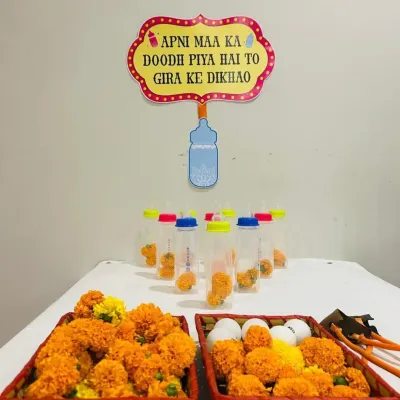 We love adding a dose of humor to our events. This baby bottle bowling game, set up with marigolds and a funny sign, is a perfect icebreaker and a fun activity for guests at a Godh Bharai.