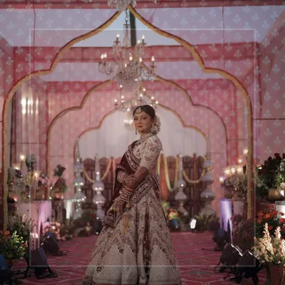A portrait of a radiant bride against the backdrop of her wedding decor. The intricate details of the mandap and her stunning lehenga come together to create a picture of pure elegance.