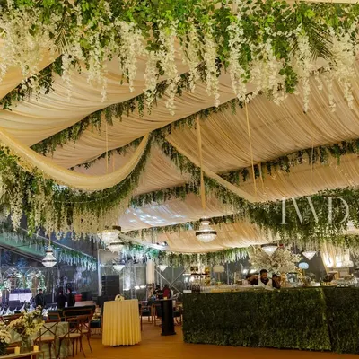 A 'Midsummer Night's Dream' Sangeet, where we created an enchanted garden inside a tent. The ceiling was draped with fabric and hanging wisteria, with a lush green bar running along the side.