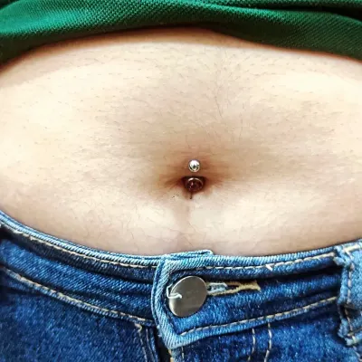 The final result of a classic belly button piercing, centered and fitted with a simple, high-quality barbell. My goal is a piercing that heals well and looks great.