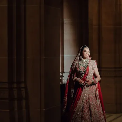 A full-length view of Nikita's timeless Anamika Khanna lehenga. We wanted a regal look that complemented the grandeur of Umaid Bhawan, and this outfit was the perfect choice for her red bride vision.