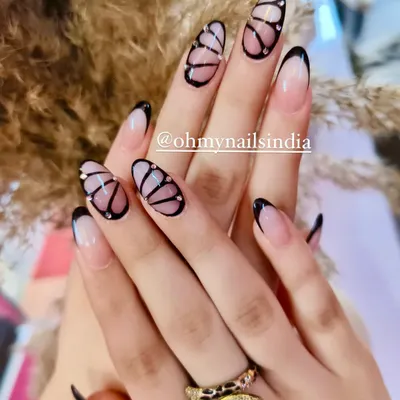 Believe in manicures that are a work of art. This intricate design features hand-painted butterfly wings with delicate black outlines and tiny crystal accents.
