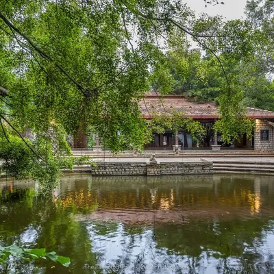 The Pond Pavilion and its perfect reflection in the tranquil Kalyani, surrounded by lush greenery. This space offers a serene, cinematic backdrop for any ceremony.