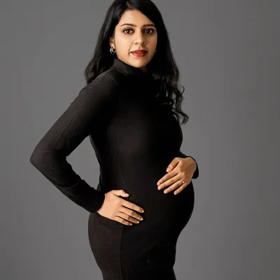 A classic three-quarter portrait in a simple black dress against a solid grey backdrop. This minimalist approach puts all the focus on your beautiful form and expression.