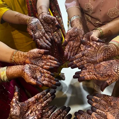 A beautiful shot of multiple hands adorned with detailed mehendi designs. We specialize in bridal and party mehendi and also teach these designs in our classes.