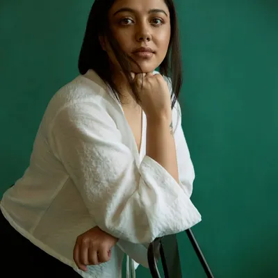 A simple portrait against a rich green backdrop. The color provides a beautiful contrast while the soft light and relaxed pose create a feeling of calm and approachability.