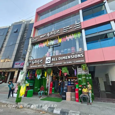 A daytime view of my 'All Dimensions' showroom in Bangalore. You can see the wide range of products we offer, from artificial grass and wallpapers to louvers, decking, and cladding.