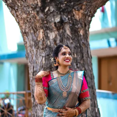 Our beautiful bride glowing in a teal blue silk saree with a contrasting pink embroidered blouse for one of her wedding functions.