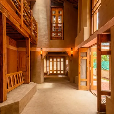 The main hallway of the mud house is a testament to thoughtful, eco-conscious design. My aim was to capture the impressive sense of space created by the high ceilings and the warm, earthy tones of the mud walls, all illuminated by beautiful, natural light.