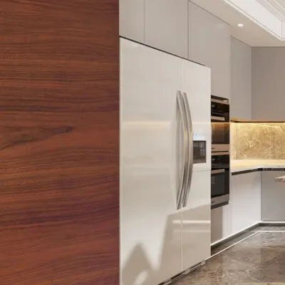 A close-up of a modern kitchen, showing the seamless integration of the refrigerator with high-gloss white cabinets and a rich American walnut wood panel.