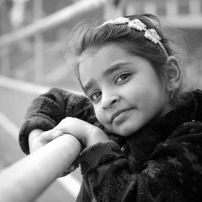 A classic black and white portrait of a young girl. The monochrome style emphasizes her gentle expression and captures a timeless, candid moment.