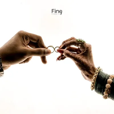 A creative and symbolic shot of the couple's hands holding their wedding rings. This highlights the commitment they are about to make.
