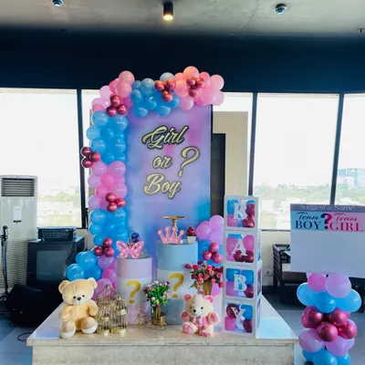 A "Girl or Boy?" gender reveal party setup. This stage uses a mix of pink and blue balloons, a custom backdrop, and themed props like teddy bears and "BABY" blocks to build excitement for the big reveal.