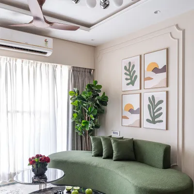 A modern living room from 'Project Modern Muse' featuring a stylish curved green sofa, abstract wall art, and a striking globe chandelier.