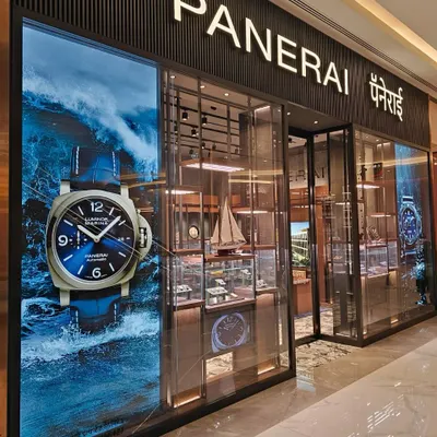 The facade of the Panerai boutique at Jio World Plaza, Mumbai, makes a bold statement, reflecting the brand's deep connection to the sea. A large, dynamic visual of the Luminor watch is paired with a transparent entrance, inviting patrons to step into the world of Italian naval heritage and horological precision.