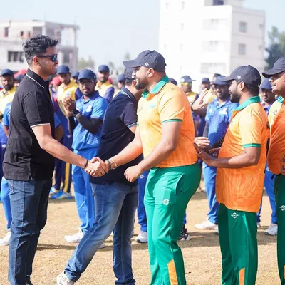 A moment of sportsmanship captured at the Indian Corporate Cricket League, with players shaking hands.