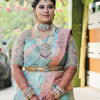 The personification of elegance and beauty. This gorgeous bride is wearing a full bridal mehendi that complements her stunning pastel blue and pink saree and pearl jewelry.