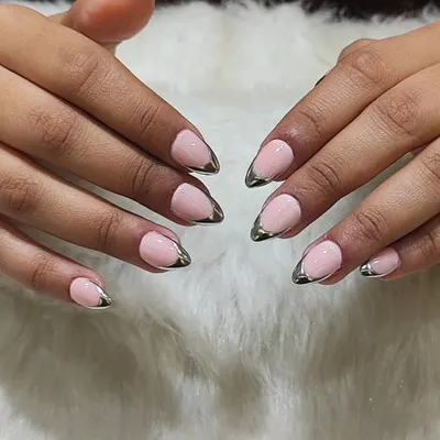 A chic and modern take on a classic. This look features a soft pink base with a metallic silver chrome tip, updating the traditional French manicure with an edgy, futuristic feel.