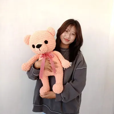 Here I am with a large, soft-pink teddy bear I just finished. These big plushies are made with extra-chunky yarn and are perfect for hugging.