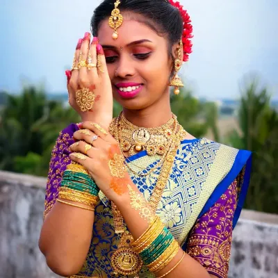 A beautiful outdoor portrait from a puberty ceremony. The focus is on the intricate henna design and gold jewelry, with a soft smile that captures the joy of the occasion.