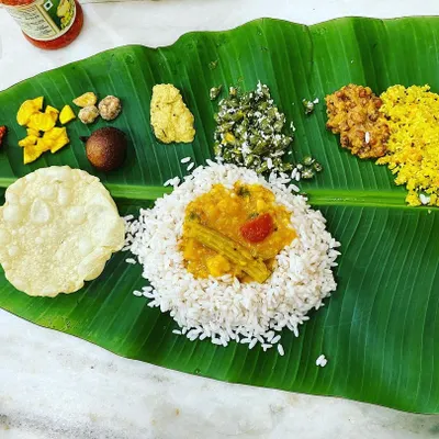 A full Kerala Sadya served on a fresh banana leaf. This is the heart of my cooking, a traditional vegetarian feast with rice, sambar, pickles, pappadam, and various vegetable dishes, just like the ones I grew up with.