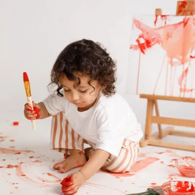 A little artist at work. A paint smash session is a fantastic and fun alternative to a cake smash, letting your child's creativity run wild.