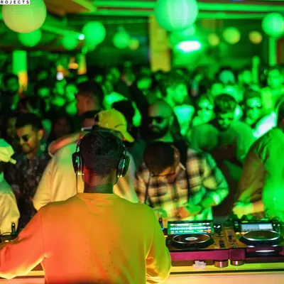 From my perspective at a sundowner set at The Ritz-Carlton, Bangalore. The green lighting and packed rooftop created an unmatched energy.