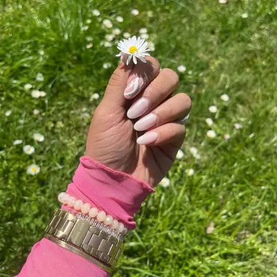 A happy client showing off her fresh, natural-looking manicure with a subtle white swirl accent nail. We love seeing our nail art out in the wild!
