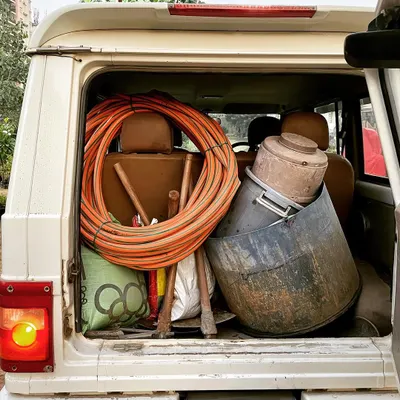 My vehicle loaded up with all the necessary landscaping equipment for a day's work. Having the right tools on hand, from pipes and shovels to water containers, means I'm always prepared for the job. Kaam pe dhyaan hai.