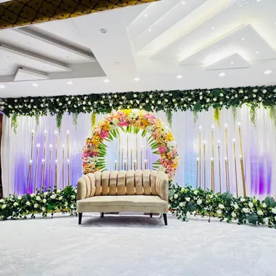 A beautiful stage setup at Grand Utsav banquet hall in Kharghar. The circular floral arrangement is the centerpiece, surrounded by candle-like lights that create a soft, romantic glow for an engagement or reception.