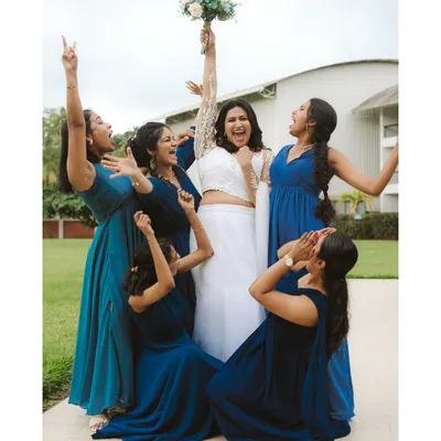 A bride and her bridesmaids erupt in celebration. This fun, energetic shot captures the joy and support of her closest friends as they cheer for her on her big day.