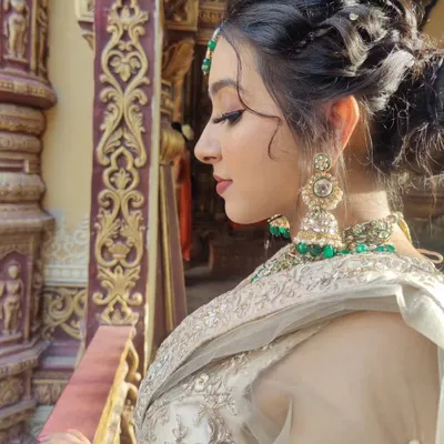A side profile showcasing the complete look, from the intricate braided updo to the soft glam makeup. The focus is on defined eyes and a flawless profile, perfect for event photography.